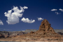 View over the lake toward rocky landscape with white cloud formations above