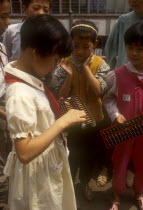 Young school girl using wooden abacus