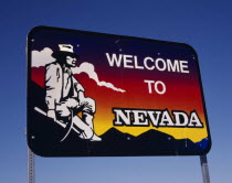 Welcome to Nevada roadsign with gold-digger looking across towards mountains and clouds at sunset