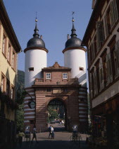 The Bridge Gate with white twin towers and black domes on a cobbled street