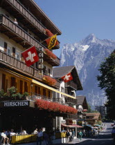 Main street and hotel e distancewith flags on the balconies and a snowcapped mountain in t