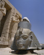 The Ramesseum  large fallen carved stone head of Ramses II at foot of the remains of Osiride Columns which depict Ramses as Osiris  god of the underworld.