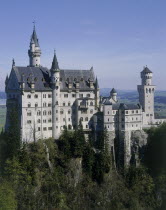 Neuschwanstein Castle of King Ludwig on a rocky hill amongst trees