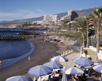 Playa de la Americas with black sandy beach and apartments in the distance