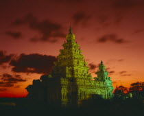 Shore Temple.  Tower floodlit at dusk with dramatic orange sky and clouds