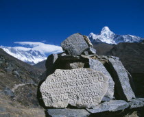 Mani stones in foreground with snow capped peak of Mount Everest behind.