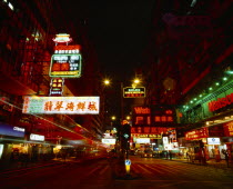 Nathan Road at night with colourful neon lights  traffic and  pedestrian crossing.