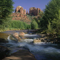 River cascading over rocks below the mountains and trees