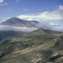 The volcano shrouded in cloud after the eruption with the devastated landscape below