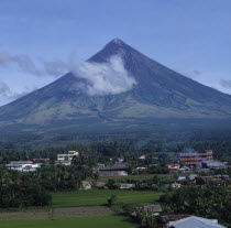 Mayon volcano with wispy cloud and village at the base