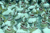 Carnival dancers in red gold and white spinning around in procession
