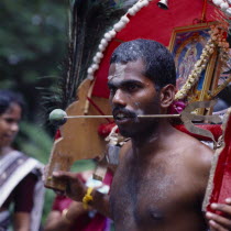 Male devotee Tahipausam Hindu festival needles pierce tongue/cheek