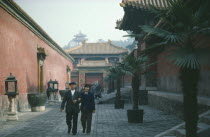 Inside the Forbidden City with chinese couple walking arm in arm