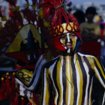 Boy at Ati-Atihan  festival with striped painted body and wearing a red headdress