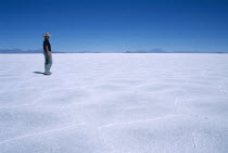 Salar de Uyuni.  Person walking across vast expanse of salt lake.