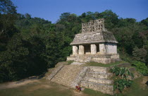 Mayan ruins dating from 600 to 900 AD.  Temple of the sun with tourist couple at foot of flight of steps to entrance.