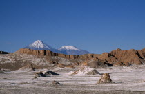 Salt deposits on desert surface near San Pedro de Atacama with snow capped peak of Volcano Lincancabur beyond.5916 m