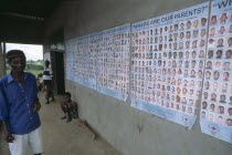 Man standing next to Red Cross tracing posters of Liberian children whose parents are missing
