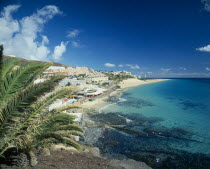 Morro del Jable.  Coastal town with hotels and apartments stretching up hillside and overlooking the sea.