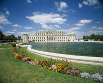 Belvedere Castle exterior and ornamental lake with colourful flower border in the foreground. Colorful