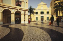 Church of St Dominic.  Exterior with people walking across mosaic tiled area in the foreground.Former portuguese territory reverted to Chinese rule in 1999