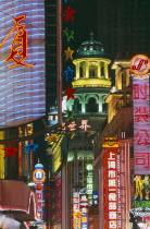 Nanjing Road at night with illuminated neon signs.