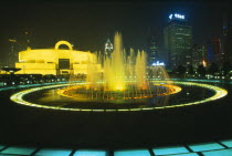 Shanghai Museum of Chinese culture built in the 1930s and converted to a museum in 1952.  Exterior and city buildings illuminated at night with fountain in foreground.