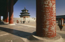 Temple of Heaven.  Hall of Prayer for Good Harvests through colonnade of pillars with peeling red paint.  Peking