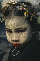 Portrait of young girl with face decorated with leaf patterns  and makeup.Burma Myanmar