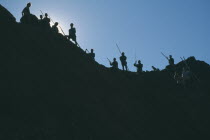 Gold workers silhouetted against sky at the source of the Ayeyarawady River at the confluence of the Mali Kha and the Ma Kha rivers in upper Myanmar.Burma