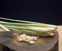 Lemon grass with sliced ends on a wood block cutting board