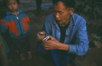 Lisu elder reading a pair of chicken wings for oracular signs