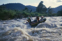 Western tourists and Thai guides white water river rafting on the Mae Taeng River