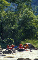 Western tourists and Thai guides white water river rafting on the Mae Taeng River