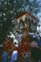 Revered monks funeral procession to cremation grounds with people pulling the funeral carriage