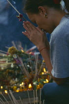 Inthakhin Ceremony. Worshipper praying beside offerings