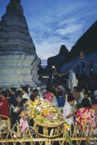 Inthakhin Ceremony. People with offerings of flowers and joss sticks circimambulating