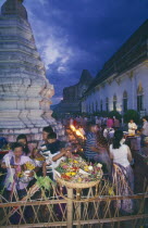Inthakhin Ceremony. People with offerings of flowers and joss sticks circimambulating