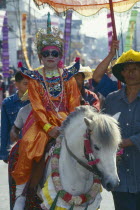 Shan Poi San Long. Crystal Children ceremony with child in costume riding a pony in the parade prior to novice monk ordination