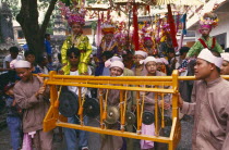 Shan Poi San Long. Crystal Children ceremony with musicians in Shan costumes playing gongs in parade to Wat Pa Pao