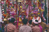 Shan Poi San Long. Crystal Children ceremony with Luk Kaeo in costumes sitting on mens shoulders at Wat Pa Pao