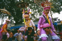 Shan Poi San Long. Crystal Children ceremony with Luk Kaeo in costume being carried on mens shoulders at Wat Pa Pao