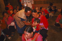 Lisu shaman giving infant liquid at healing ceremony