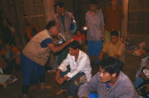 Lisu shaman spraying supplicants head at healing ceremony