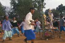 Lisu people dancing around New Year tree to a banjo player