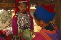 Young Lisu girl dressed in her New Year finery while her mother adjusts her tunic