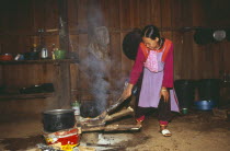 Young Lisu woman working in her kitchen in Bahn Mai Phaem