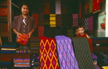 Kachin woman selling sarongs and other textiles at the market Burma