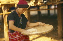 Sgaw Karen woman using a bamboo tray to sift pounded rice