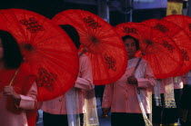 Women carrying Sah paper umbrellas marching in the Flower Festival Parade